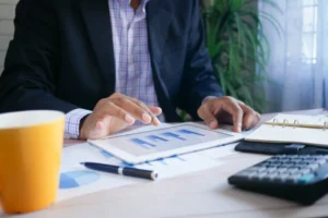 Empresário analisando alternativas ao crédito bancário para financiar o seu negócio com documentos e calculadora sobre a mesa